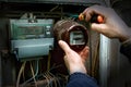 The electrician dismantles the old analog electricity meter